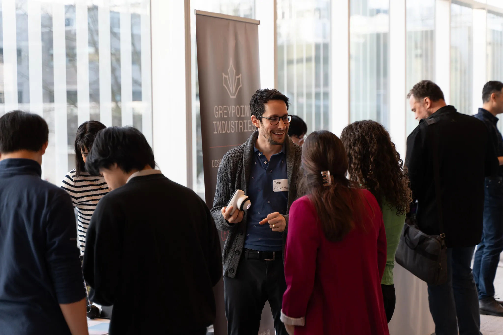 Attendees networking in a bright lobby at C50 Cohort Day