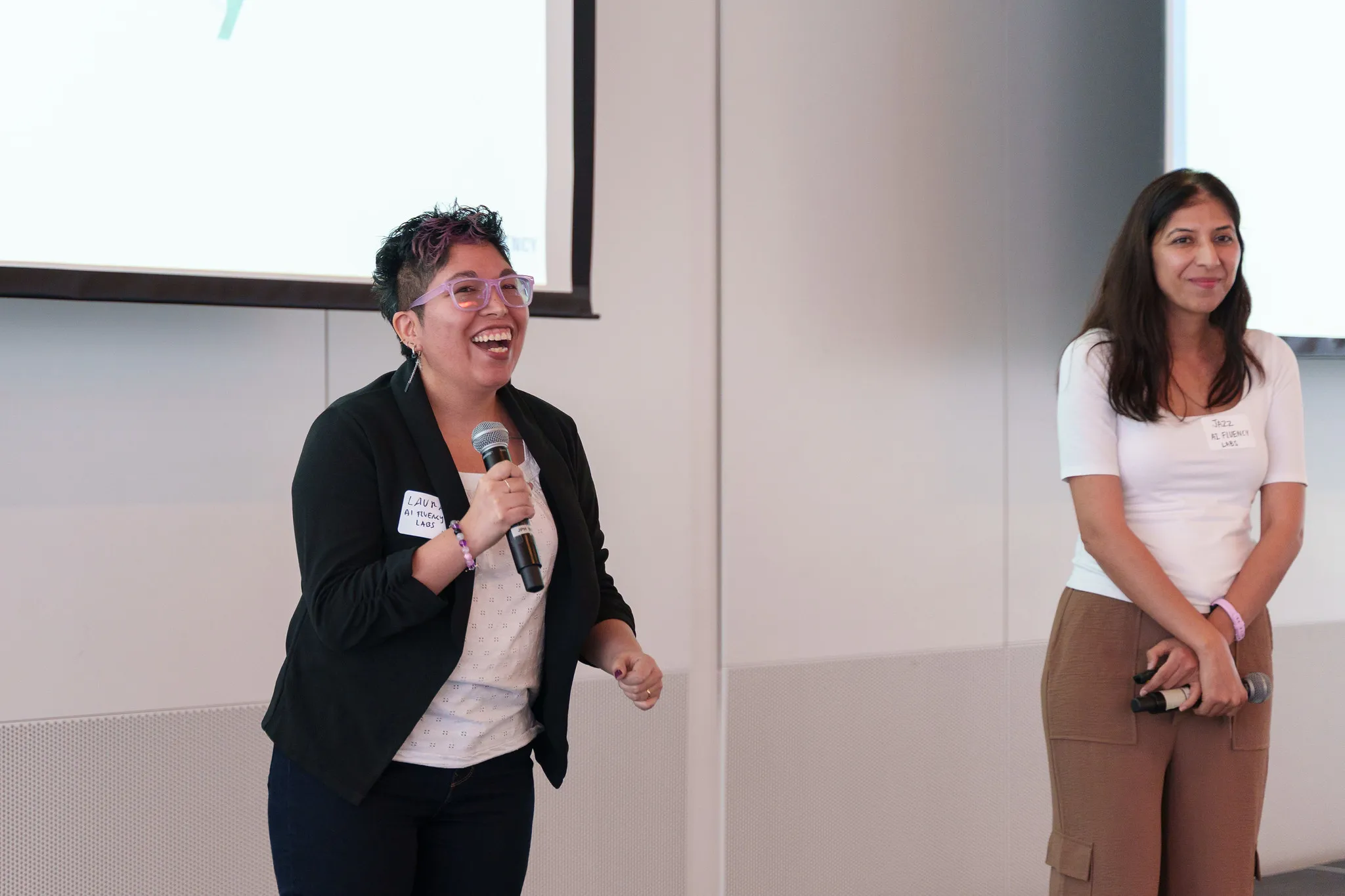 Two presenters sharing a laugh at the front of the room during Venture Founder Session 16